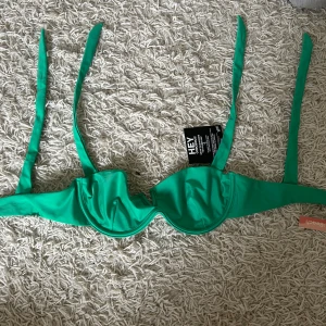 Helt ny grön bikini från Nelly beach - Snygg grön bikini från Nelly Beach som är helt ny med bygel och knytband på överdelen samt högt skurna trosor med rynk bak. Överdelen är i storlek 70D och trosorna M. Priset kan diskuteras!🙌🏼