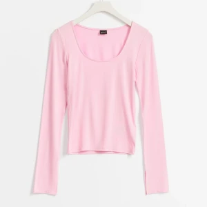 Ljusrosa långärmad topp med slits vid ärmslut - Säljer en ljusrosa långärmad topp med rundad urringning och slitsar vid ärmsluten. Toppen är figurnära och tillverkad i ett mjukt, stretchigt material som passar perfekt till vardags eller när du vill känna dig extra bekväm.