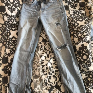Ljusblåa baggie jeans med hål från Gina tricot.  - Ljusblå jeans med hål i och från gina tricot. Använt några gånger och är mera baggie byxor och lite öppna längst ner i benen. 
