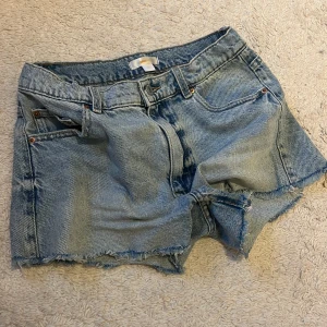 Ljusblå jeansshorts med fransig kant från Gina Tricot - Säljer ett par ljusblå jeansshorts från Gina Tricot i storlek 158. Shortsen har rå, fransig kant nertill 
