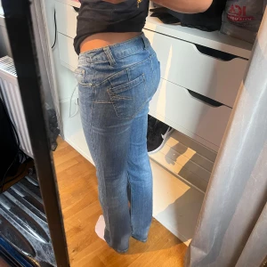 Blå bootcut jeans med låg midja - Snygga blå jeans med bootcut passform och låg midja. Klassisk femficksmodell med ljusa sömmar och lätt tvättad look. Perfekta för dig som gillar en avslappnad men ändå trendig stil.