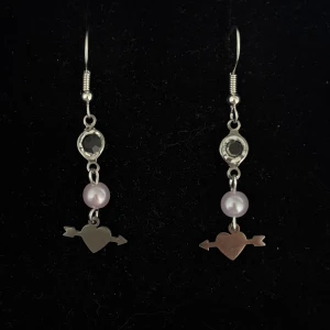 Silverörhängen med hjärta och ljusrosa pärla - Handgjorda och unika silverörhängen 🤩 Öronhängerna är nickelfria och silverpläterade i kirurgiskt stål, resterande av örhänget är i rostfritt stål (ej silverpläterat) 💕🙏 4 cm långa. Alla köp görs via ”KÖP NU” knappen.  💐