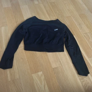 Svart croppad träningströja från ICANIWILL - Säljer en svart croppad långärmad träningströja från ICANIWILL. Tröjan har en tight passform och är tillverkad i ett stretchigt material. Nypris 449 säljer för 299