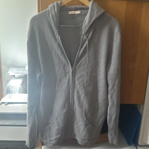 Grå cashmere hoodie från Luca Faloni - Luca Faloni hoodie i en grå/blå färg. Mycket bra skicka och väl omhändertagen. 100% cashmere. Nypris 4800 kr. Storlek M, passar även storlek L. Riktigt skön passform och perfekt till lite kyligare väder. Dustbag ingår vid köp. Hör av er vid prisförslag och andra frågor!