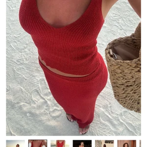 Röd glittrig ribbad linnetopp  - Säljer en röd glittrig ribbad linnetopp från Designbysi med smala axelband och v-ringning. Toppen är figurnära och croppad, perfekt till sommarens alla tillfällen. Materialet är stretchigt och ger en snygg passform. Helt ny och oanvänd. Denna topp ingår i ett sett, kjolen finns även att köpa