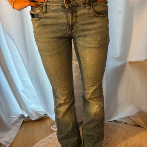 Blå bootcut jeans från Lee - Snygga blå jeans från Lee med bootcut-modell och klassisk femficksdesign. Jeansen är mid waist och är tillverkade i mjukt denimtyg med lätt tvättad look. Perfekta för dig som gillar en tidlös och avslappnad stil. Jeansen har ett litet hål i skrevet, pris kan diskuteras.