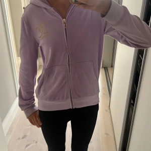 Juicy couture zip hoodie rosa/lila - En äkta juicy couture zip hoodie som var köpt för 800kr men säljs för 90kr då lappen är borta och det finns några mini fläckar.  Den är lite för liten för mig som är 165. 