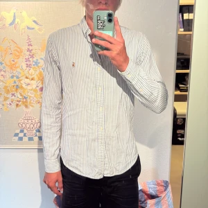 Randig skjorta från Polo Ralph Lauren - Snygg blåvit randig skjorta från Polo Ralph Lauren med klassisk button-down krage och broderad logga på bröstet. Skjortan är i bra skick och i strl M, bara skriva om man har några frågor👍