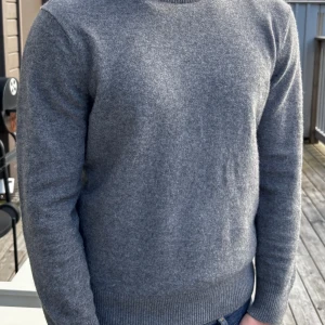 Grå kashmirtröja från Massimo Dutti - Säljer en stilren grå kashmirtröja från Massimo Dutti i storlek M. Tröjan har rund halsringning, ribbade muddar och är långärmad. Perfekt för dig som gillar en klassisk och clean look med mjukt material. 