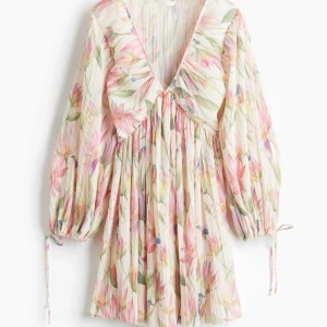 Blommig kortklänning från H&M - Superfin kortklänning med plisserat tyg från H&M i storlek XXS (slutsåld). Aldrig använd men utan prislapp❣️