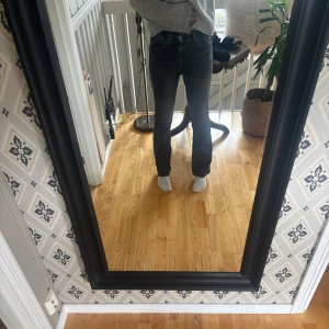 Svarta raka jeans med medel/låg midja - Snygga svarta jeans med medel/låg midja och raka ben. Jeansen har klassisk femficksdesign och är tillverkade i stretchig denim som sitter skönt. Perfekta till en avslappnad look och passar till det mesta i garderoben.