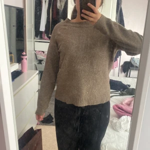 Brun stickad tröja från ONLY - Mysig brun stickad tröja från ONLY med rund halsringning och långa ärmar. Enkel och stilren modell som är perfekt för lager-på-lager. Tröjan har ribbade muddar vid hals, ärmslut och nederkant. Passar dig som gillar en klassisk och chill look. Lite liten i storleken. 