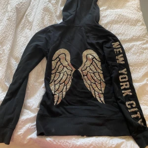 Victoria secret hoodie  - Jättefin Victoria secret hoodie säljs inte längre! Glittriga vingar bak och text på ena ärmen där det står New York City! Knappt använd köpt på vinted förra våren🩷