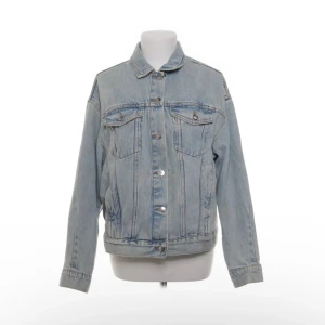 Ljusblå jeansjacka från H&M Divided - Säljer en klassisk ljusblå jeansjacka från H&M Divided i storlek S. Jackan har raka linjer, två bröstfickor med knappar och knäppning framtill. Perfekt för lager-på-lager och enkel att styla till olika outfits.