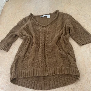  stickad tröja  - Säljer en brun stickad tröja från Édéis med snyggt flätmönster framtill. Tröjan har trekvartsärm och ribbade muddar. Perfekt höst tröja!💕