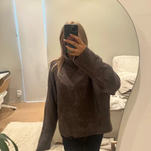 Brun ribbstickad polotröja - Mysig brun ribbstickad polotröja med oversized passform och långa ärmar. Perfekt för lager-på-lager och chill dagar. Tjockt, stickat material som håller dig varm och stilen är enkel men ändå trendig.