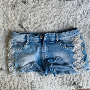 Lowwaist jeansshorts med spets och pärlor - Snygga low waist jeansshorts i strl 36, midja:38. Kommer fler unika jeansshorts/kjolar så följ!!