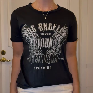 T-shirt Gina Tricot  - Mörkgrå t-shirt med vitt tryck ifrån Gina Tricot. Inget tryck på ryggen. Storlek S, normal i storleken. Fint skick! 100% bomull