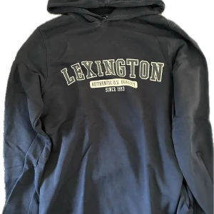 Lexington hoodie  - Mörkblå hoodie från Lexington – en klassiker med premiumkänsla! Tillverkad i mjuk och tjock bomull med Lexington-logo framtill. Perfekt för både hemmamys och en avslappnad vardagslook. Tidlös färg som passar till allt. Inga fläckar eller skador – redo för ny användning!