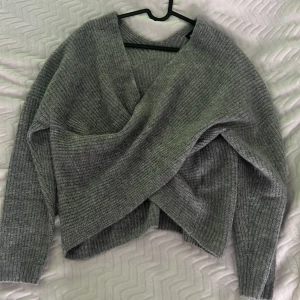 Grå omlottstickad tröja Even&Odd - Mysig grå stickad tröja från Even&Odd i omlottmodell. Tröjan har lång ärm, ribbad struktur och en snygg v-ringning framtill. Aldrig andvänd❤️