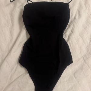 svart body  - Enkel och stilren svart body från H&M i storlek XS. Modellen har tunna axelband och en klassisk, tight passform som framhäver figuren. Det är vaddering vid bysten 🙌🏼 Säljes då den blivit för liten för mig💕💕