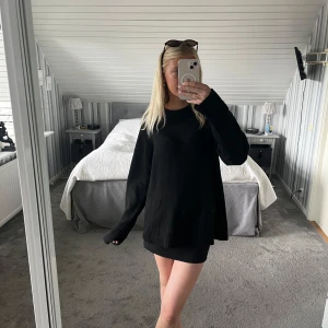 Svart oversized stickad tröja - Säljer en svart oversized stickad tröja med rund hals och långa ärmar. Tröjan har breda ribbade muddar vid ärmslut och nederkant, vilket ger en chill och avslappnad vibe. Perfekt att slänga på sig över en kjol eller jeans.