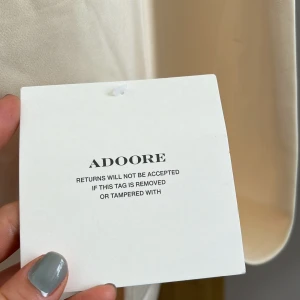 Champagnefärgad långklänning från Adoore - Säljer en elegant långklänning från Adoore i champagnefärgad satin. Stadig passform - sexig och välklädd at once. Helt ny och fantastiskt fin, säljer endast pga fel färg till mina brudtärnevänner :) 