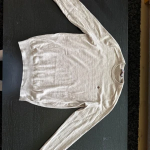 Beige merino tröja från Morris - Säljer en stilren beige stickad tröja från Morris med rund halsringning och som passar till många olika outfits. Tröjan har krympt lite i tvätten så skulle klassa tröjan som S/M
