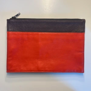 Kuvertväska från Twist & Tango - Jättefin kuvertväska från märket twist&tango💕Den har inga defekter alls och är så gott som ny.  Väskan har en ficka framtill och en liten mindre ficka inuti. Den har två färger, den ena röd och den andra lite brun/lila aktig. Sista bilden är tagen i solljus för att bättre framhäva färgerna. Skriv gärna vid frågor eller funderingar☺️