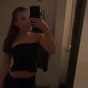 Svart tubtopp - Säljer en svart tubtopp med lite formad urringning. Toppen är croppad och har en enkel, stilren design utan synliga detaljer. Perfekt att matcha med jeans eller kjol för en trendig look. Skriv privat för fler bilder eller andra frågor 💞