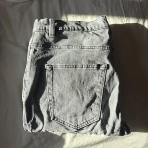 Grå jeansbyxor Hank Regular Fit - Säljer ett par grå jeansbyxor i modellen Hank Regular Fit. Byxorna har klassisk femficksdesign, bälteshällor och stängs med knapp och dragkedja. Perfekta för dig som gillar en enkel och stilren look. Använd 1 gång från Kappahl 
