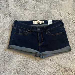 Mörkblå jeansshorts från Hollister - Man kan välja hur mycket man vill vika upp🙌🏼eller klippa av dom mer🤗Snygga mörkblå jeansshorts från Hollister med klassisk femficksdesign och uppvikta benslut. Shortsen har kontrastsömmar och läderpatch med logga bak. Skriv om ni vill ha egna bättre bilder eller mått och sånt💗jag vek upp dom ganska slarvigt men man kan vika hur man vill❣️