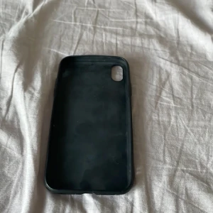 Svart mobilskal till iPhone XR - Säljer ett enkelt svart mobilskal som passar till en smartphone med kameraöppning i hörnet. Skalet är stilrent och skyddar mobilen mot repor och stötar. Perfekt för dig som vill ha ett diskret och klassiskt skydd till din telefon.