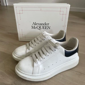 Vita sneakers från Alexander McQueen - Stilrena vita sneakers från Alexander McQueen. Perfekta för dig som gillar en clean och modern look. Låda och dustbag medföljer.                      Pris kan diskuteras.