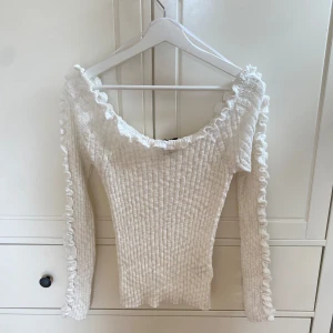 Vit gullig ribbad tröja med volang  - Säljer min supersöta vit ribbad tröja från Lindex med volangdetaljer längs halsringning och armarna. Aldrig använd🥰