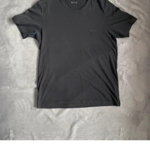 Svart t-shirt från BOSS - En stilren svart t-shirt från hugo boss med diskret logga på bröstet. Klassisk tröja. Perfekt basplagg i garderoben och passar fint speciellt runt armarna!🔥🔥. Nypris ~ 599, mitt pris 199!!🔥🔥