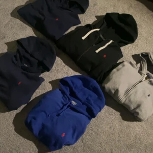 Flera hoodies från Ralph Lauren - Fem snygga hoodies från Ralph Lauren i olika färger: svart, mörkblå, blå och grå. Klassisk design med huva och broderad logga på bröstet. Perfekta för en avslappnad och sportig stil.