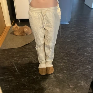 Beiga linnebyxor med dragsko - Säljer ett par beiga linnebyxor med resår och dragsko i midjan. Byxorna har raka ben och avslappnad passform, perfekta för varmare dagar. Lätta och luftiga med klassisk look. Är för små och kom inte till användning.