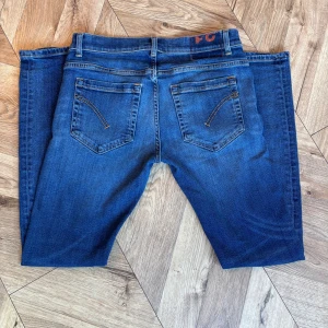 DonDup George  - Säljer ett par klassiska blå jeansbyxor från George med raka ben och snygga bakfickor med dekorativa sömmar. Jeansen är tillverkade i ett mjukt denimtyg med lite stretch. Perfekta till vardags! Storlek W31/L31