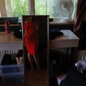 Röd offshoulder klänning - Säljer en röd, figurnära offshoulder klänning med volangdetalj upptill. Klänningen har en kroppsnära passform och slutar ovanför knäna. Perfekt för dig som vill sticka ut med en färgstark look.