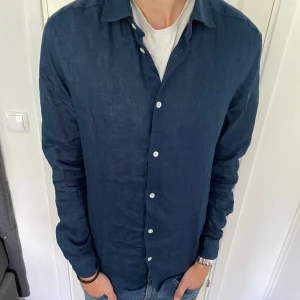Blå linneskjorta - Säljer denna sjukt snygga linneskjortan då den är för stor för mig. Nyskick. Storlek M passar M,L. Fråga gärna. 