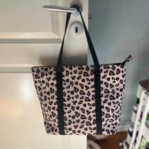 Leopardmönstrad handväska - Säljer denna jättefina handväskan ifrån Kappahl. Passar till mycket fina saker och är lagom stor som t.ex skolväska, strand väska m.m.