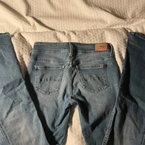 Blå jeans från Pepe Jeans💕 - Snygga blå jeans från Pepe Jeans med klassisk femficksdesign och knappgylf. Perfekta för en avslappnad stil. Märkeslapp i läder baktill ger en extra touch.