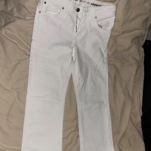 Vita jeansbyxor - Snygga vita jeansbyxor med klassisk femficksdesign och knappgylf. Perfekta för en stilren look. De har en rak passform och är tillverkade i ett bekvämt material.