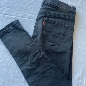Svarta jeans från Levi's 520 - Snygga svarta 520 jeans från Levi's med klassisk design och femficksmodell. De har en diskret logga på bakfickan och en bekväm passform. W30 L32. Använda så det finns slitningar (se bilderna).