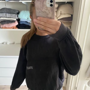 Mörkgrå sweatshirt H&M - Säljer en mörkgrå sweatshirt från H&M med tryck på framsidan. Tröjan har långa ärmar och en rund halsringning. Perfekt för en avslappnad stil med lite mer baggy passform