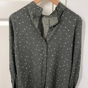 Elegant grön blus  - Säljer en stilren grön blus från H&M med vita och svarta prickar. Kan knäppas upp.💖💖