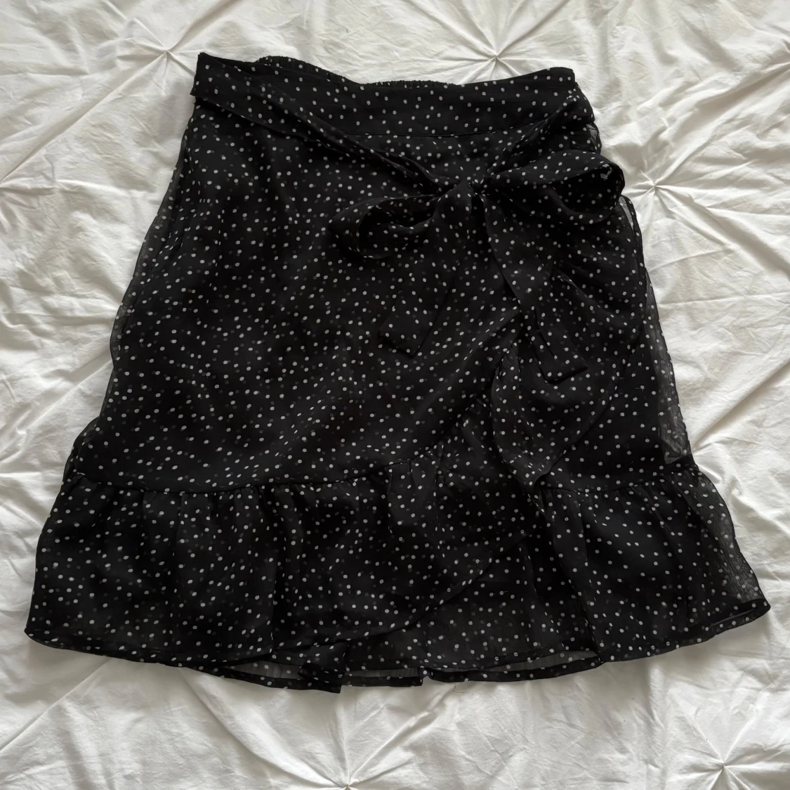 Svart prickig kjol med knyt