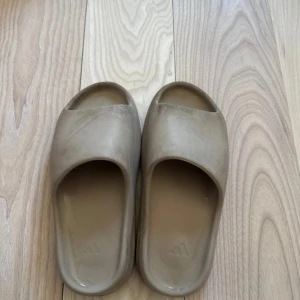 Beige sandaler från Adidas - Säljer ett par bekväma beige sandaler från Adidas. De har en öppen tå-design och en räfflad sula för extra grepp. Perfekta för avslappnade dagar. Perfekta tofflor nu inför sommaren 