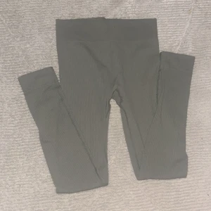 Grön ribbade leggings från H&M - Säljer ett par gröna ribbade leggings från H&M i storlek XS. De har en hög midja och är bekväma. Passar bra till idrotten/gymmet.